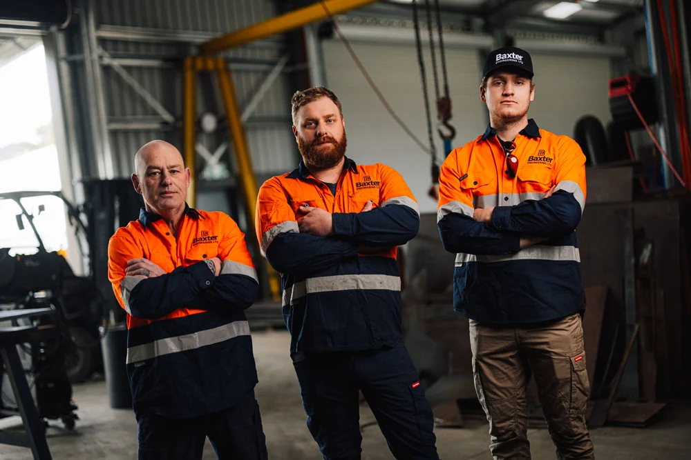 Three Baxter Auckland engineers standing in their workshop
